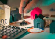 A close-up of real estate financial planning with keys, calculator, and money.