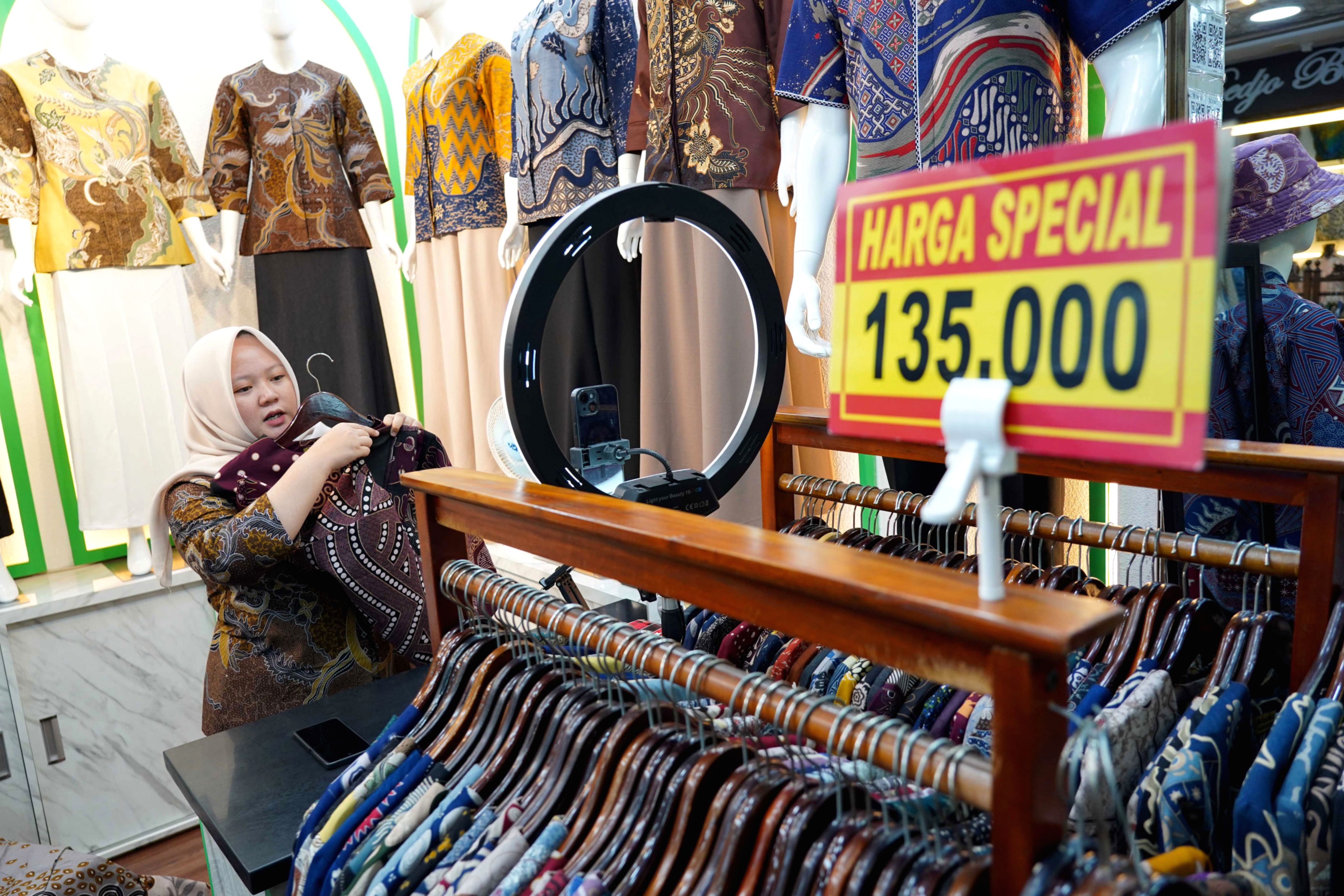 Ilustrasi pelaku usaha UMKM sedang mengoperasikan perangkat digital untuk berjualan di marketplace