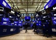 Papan layar elektronik yang menampilkan pergerakan indeks saham di Wall Street, New York.