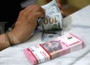 Papan layar elektronik menampilkan pergerakan nilai tukar mata uang rupiah terhadap dolar AS