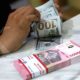 Papan layar elektronik menampilkan pergerakan nilai tukar mata uang rupiah terhadap dolar AS