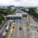 Papan penunjuk jalan tol Jasa Marga dengan latar belakang gedung perkantoran di Jakarta