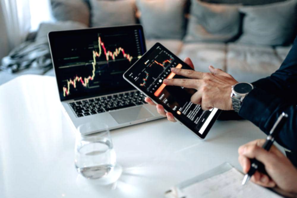 Seorang investor sedang menganalisis grafik pergerakan harga saham di layar komputer saat pasar modal fluktuatif.