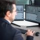Grafik pergerakan harga saham di layar monitor yang menunjukkan fluktuasi pasar