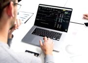 Grafik pergerakan harga saham di layar monitor yang menunjukkan tren kenaikan pasar
