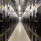 Deretan server komputer di dalam fasilitas pusat data modern dengan pencahayaan LED biru