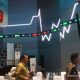 Tampilan layar monitor yang menunjukkan grafik pergerakan Indeks Harga Saham Gabungan (IHSG) yang berwarna merah