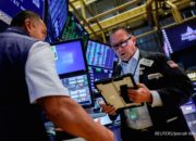 Papan layar elektronik menampilkan grafik penurunan indeks saham di bursa Wall Street, New York.