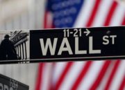 Layar monitor menampilkan grafik pergerakan indeks saham Wall Street yang sedang mengalami kenaikan