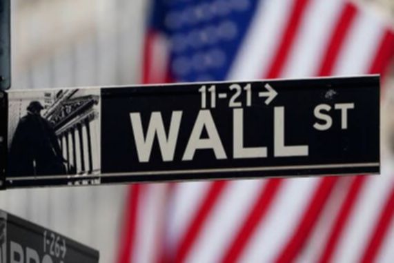 Layar monitor menampilkan grafik pergerakan indeks saham Wall Street yang sedang mengalami kenaikan