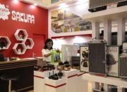 Logo PT Selamat Sempurna Tbk (SMSM) dengan latar belakang kantor perusahaan