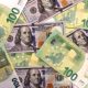 Grafik pergerakan mata uang dolar AS terhadap yen Jepang dan franc Swiss di layar monitor trading